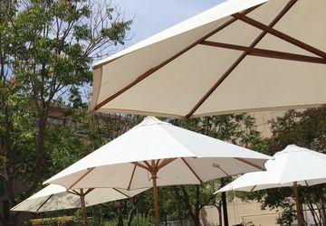 white canvas umbrellas under a blue sky at Jacaranda Courtyard