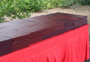 Stanford diploma holders stacked on a red-draped table